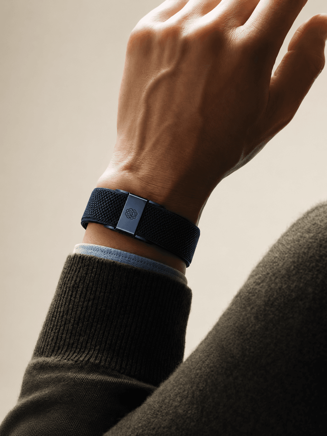 A hand wearing the NeuroAtlas band, arm raised